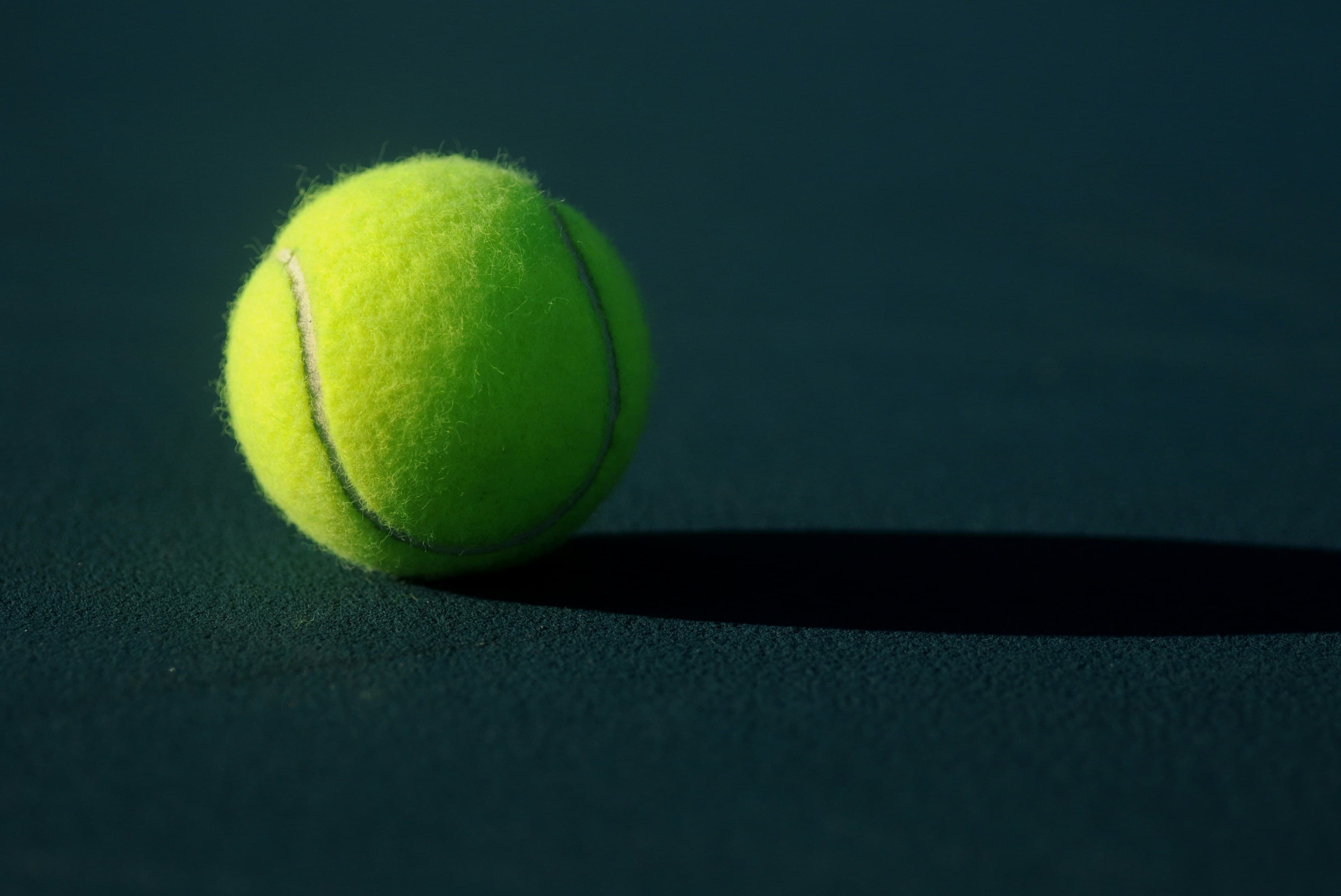 Tennis ball on dark court background